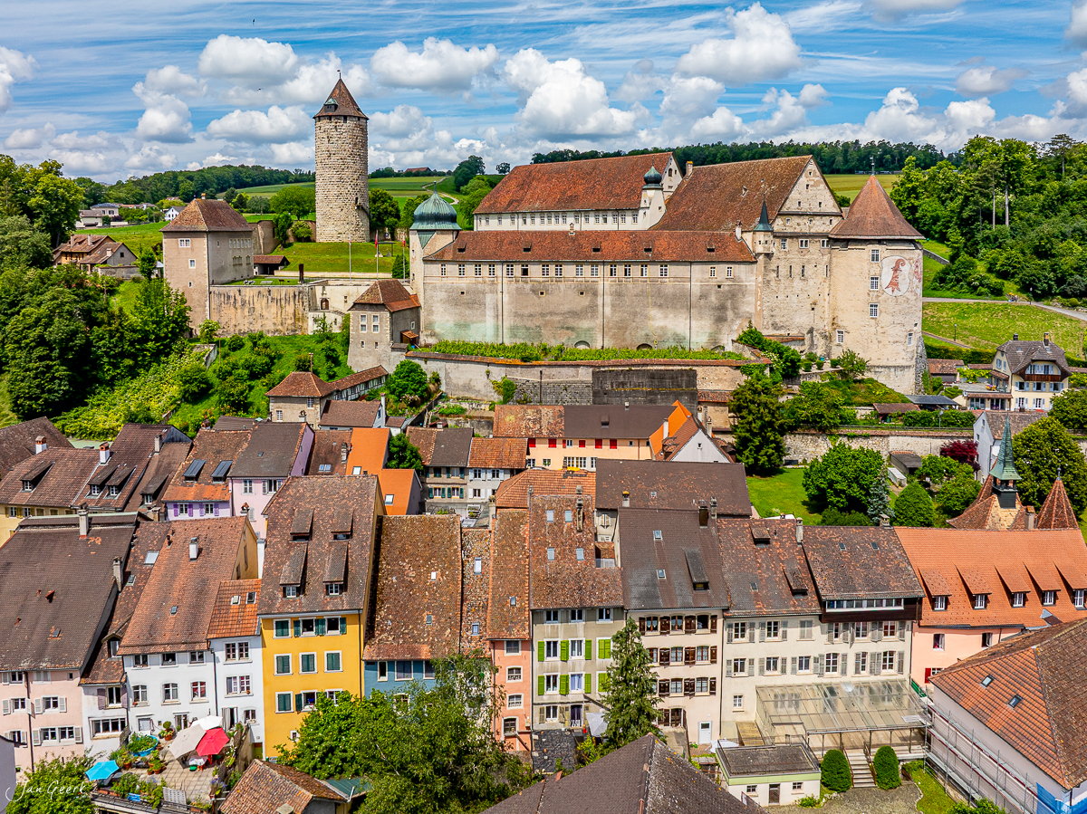 Luftaufnahme der Schlossanlage Porrentruy mit farbigen Bürgerhäusern im Jura bei Sommerlicht, Schweiz – Jan Geerk Fotograf Basel