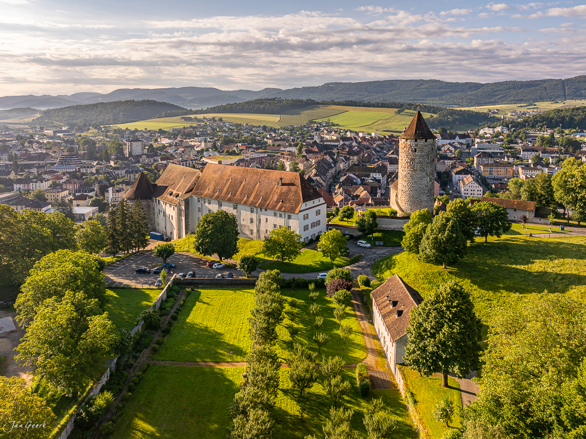 Schloss und Abtei Porrentruy mit grüner Landschaft Sommerlichtstimmung Jura Schweiz – Jan Geerk Fotograf Basel