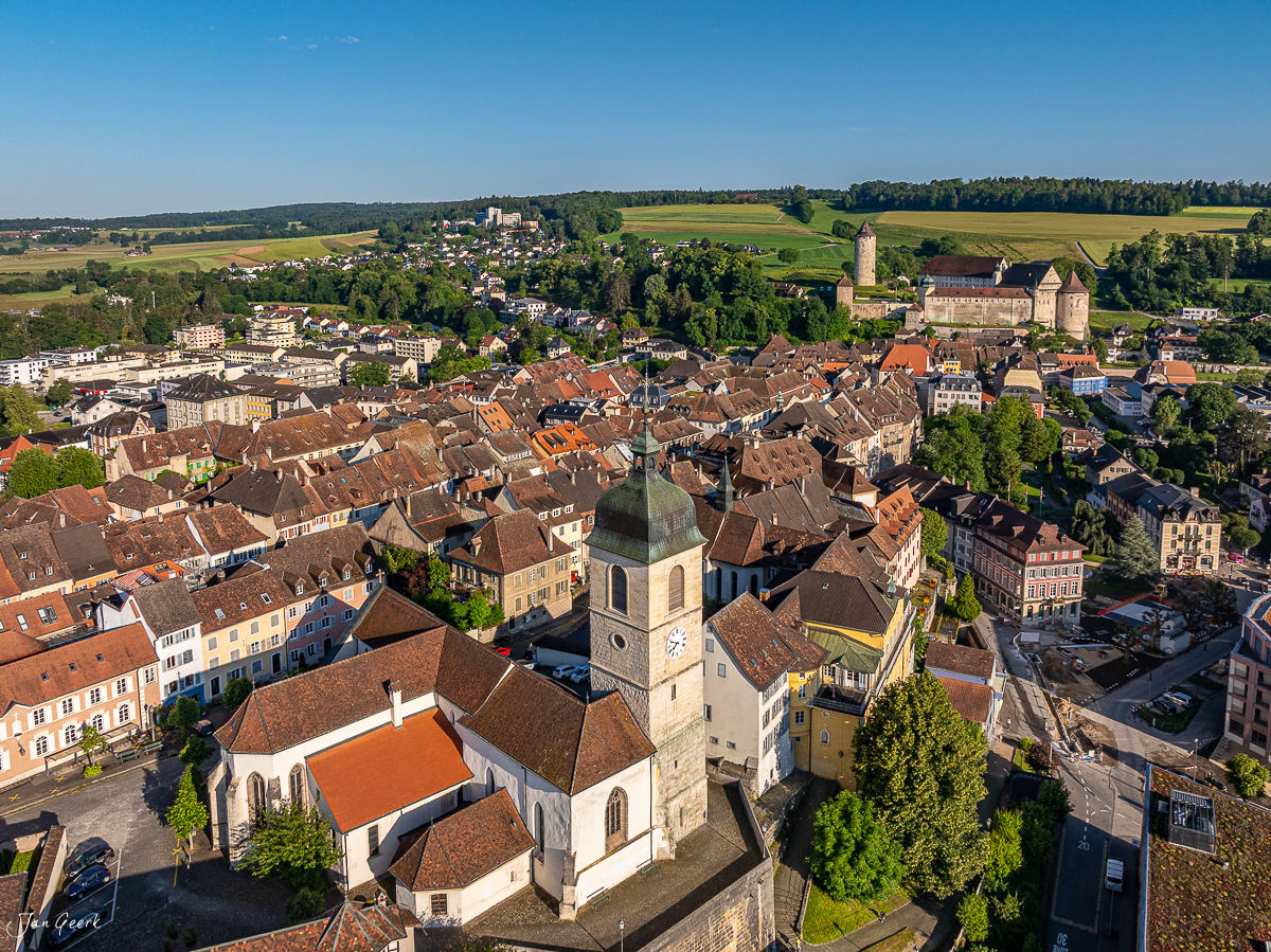 Luftaufnahme der Altstadt Porrentruy mit Kirche, Schloss und grüner Jura-Landschaft im Sommer – Jan Geerk Fotograf Basel