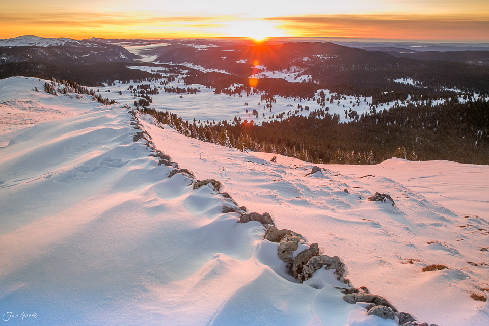 Schneebedeckte Berglandschaft bei La Dole mit goldenem Sonnenaufgang über verschneiten Tälern, Jura Schweiz – Jan Geerk Fotograf Basel