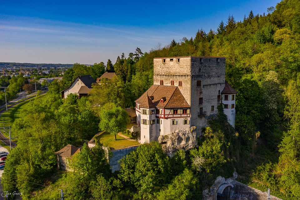 Luftaufnahme Schloss Angenstein im Frühling, umgeben von grünem Wald, Baselland Schweiz – Jan Geerk Fotograf Basel