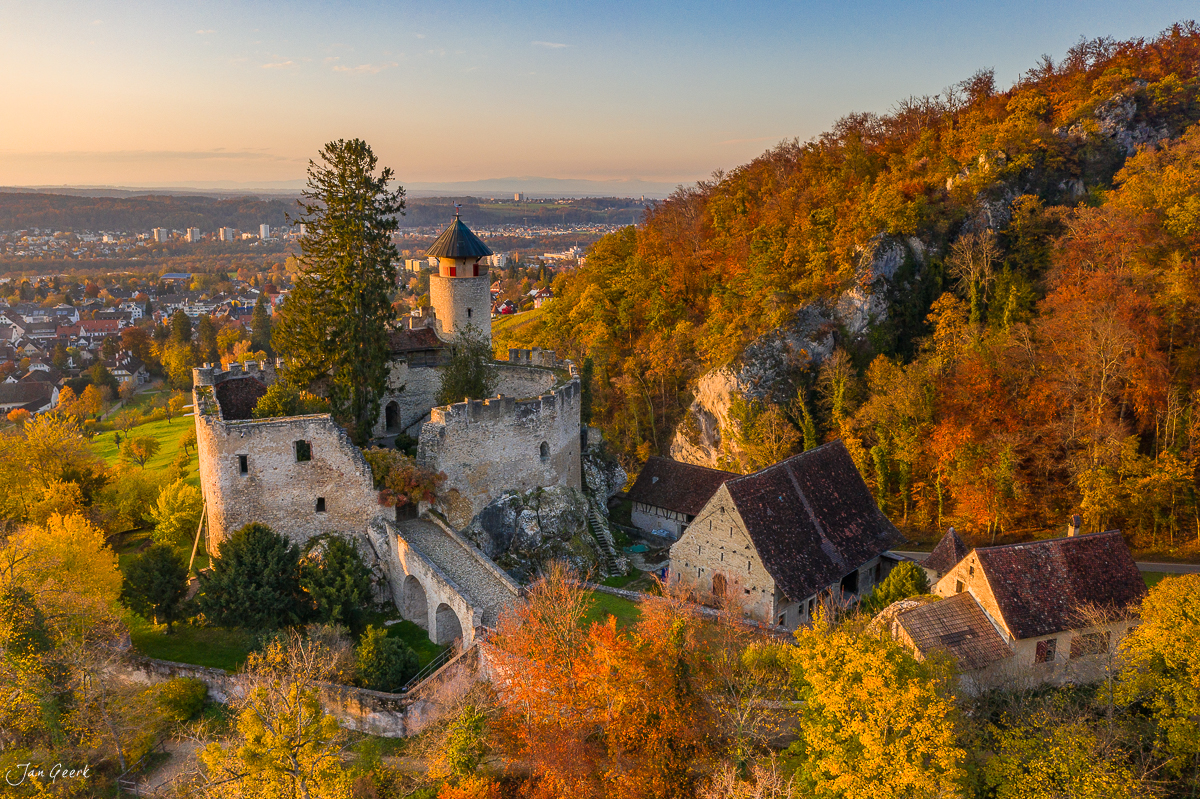 Schloss Reichenstein herbstlich in goldener Abendsonne über Arlesheim mit Herbstwald und Stadt im Hintergrund Schweiz – Jan Geerk Fotograf Basel
