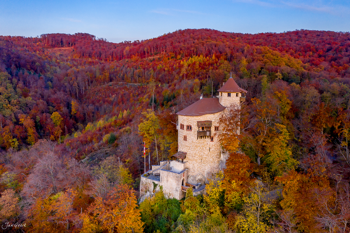 Schloss Reichenstein herbstlich umgeben von rot-goldenen Wäldern in der Birseck Schweiz – Jan Geerk Fotograf Basel