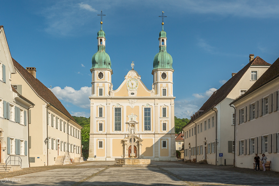 Barocke Pfarrkirche mit grünen Zwiebeldächern in Arlesheim bei blauem Himmel, sonnige Sommerstimmung Baselland Schweiz – Jan Geerk Fotograf Basel