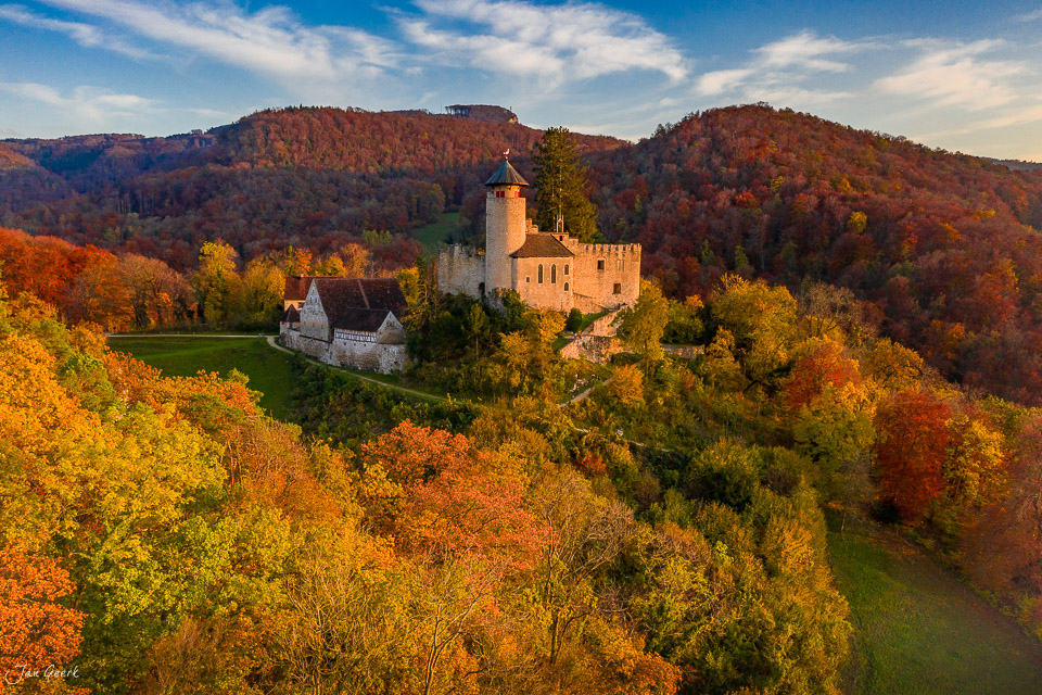 Schloss Reichenstein in herbstlicher Landschaft mit goldenem Laub bei Sonnenuntergang in der Schweiz – Jan Geerk Fotograf Basel