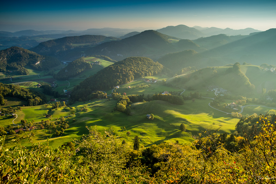 Luftaufnahme des Bölchen Tals mit grünen Wiesen, Wäldern und sanften Bergen in goldener Sommerlicht-Stimmung, Baselland Schweiz – Jan Geerk Fotograf Basel