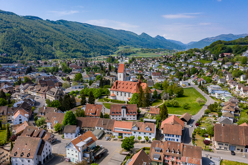 Luftaufnahme Dorf Balsthal mit Kirche, grüne Hügel, Frühling, Solothurn, Schweiz – Jan Geerk Fotograf Basel