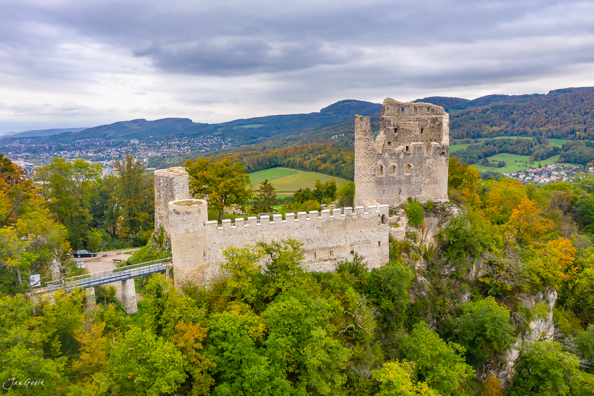 Mittelalterliche Burg Baselland herbstlich umgeben von grünem Wald und Tal, Drohnenaufnahme Nordwestschweiz – Jan Geerk Fotograf Basel