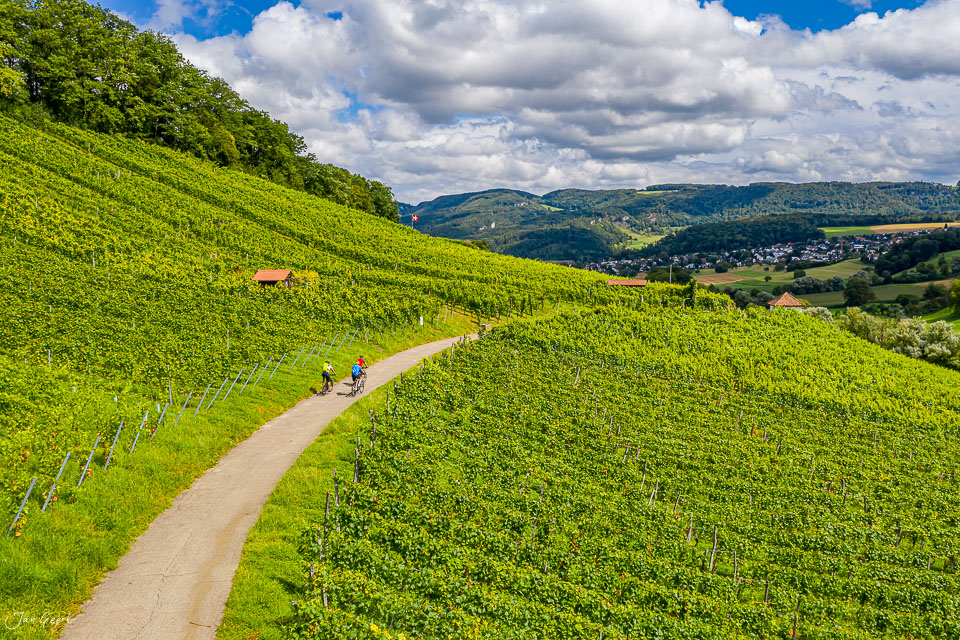 Wanderer auf Weinbergweg in Aesch mit grünem Rebberg, bewölkter Sommerhimmel, Baselland Schweiz – Jan Geerk Fotograf Basel