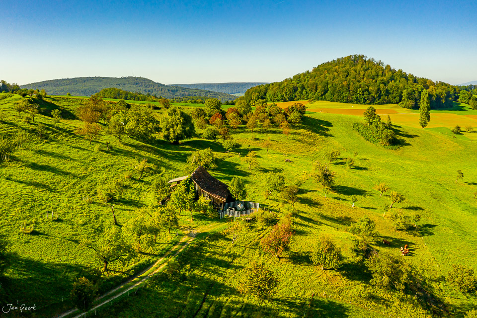 Luftaufnahme eines Bauernhauses in Arbolswil umgeben von grünen Wiesen und Wäldern im Sommer, Baselland, Schweiz – Jan Geerk Fotograf Basel