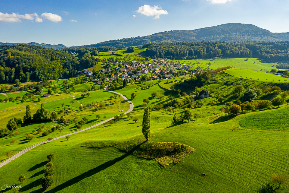 Luftaufnahme Arbotsswil mit grünen Wiesen, Dorf und Bergen im Sommer, Baselland Schweiz – Jan Geerk Fotograf Basel