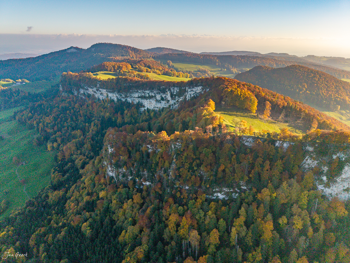 Herbstliche Luftaufnahme der Bölchenregion mit buntem Laubwald, Kalkfelsen und sanften Hügeln in goldenem Kantlicht – Baselland Schweiz, Fotograf Jan Geerk Basel