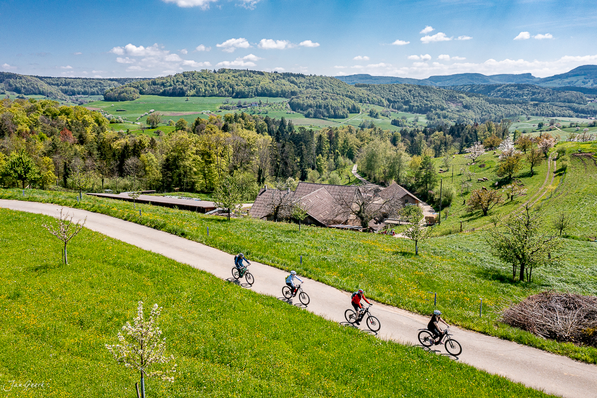 E-Biker auf Landweg Baselland Frühling grüne Wiesen Luftaufnahme Schweiz Jan Geerk Fotograf Basel