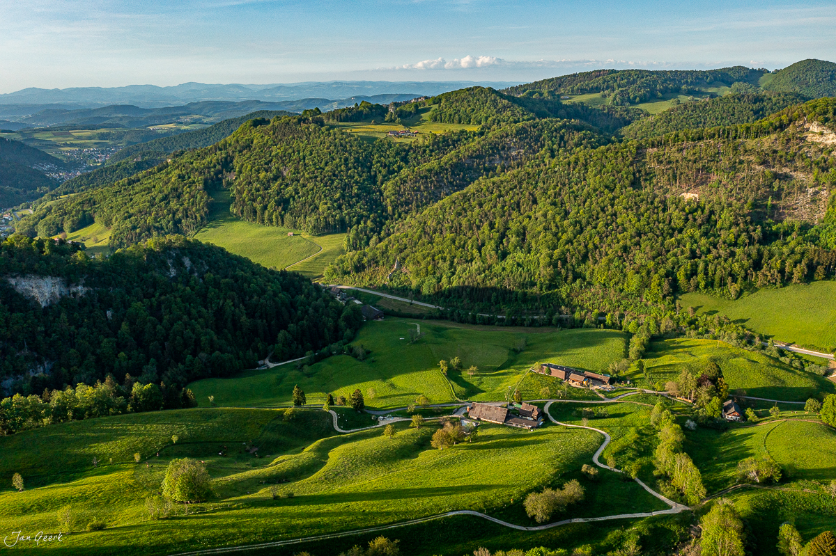 Luftaufnahme Langenbruck mit grünen Wiesen, Wäldern und Gehöften im Frühling, Baselland Schweiz – Jan Geerk Fotograf Basel