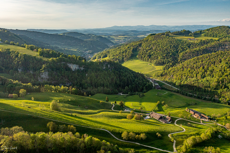 Luftaufnahme Langenbruck mit grünen Wiesen, Wäldern und Bauernhöfen im Frühling, Baselland Schweiz – Jan Geerk Fotograf Basel