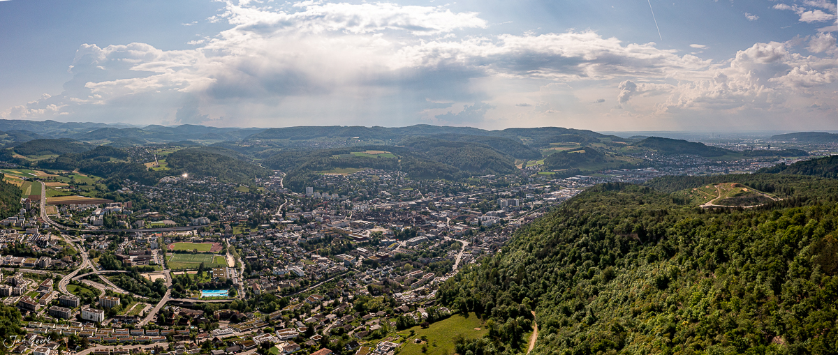 Luftaufnahme Baselland Frühling grüne Hügellandschaft mit Wald und Stadt Jan Geerk Fotograf Basel Schweiz