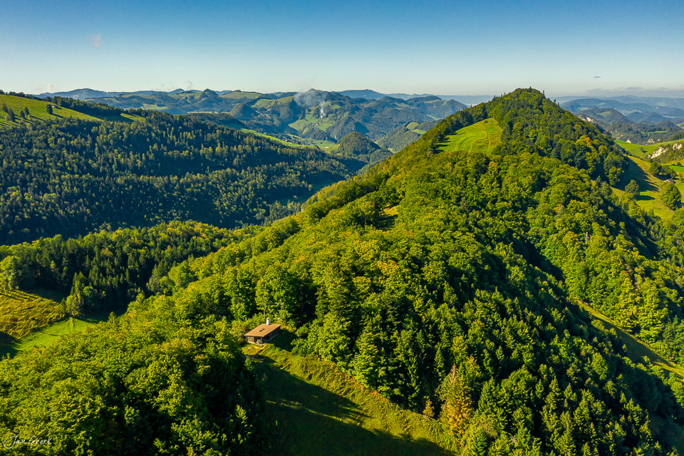 Luftaufnahme Wasserfallen mit grünen Bergwäldern, Alpenwiesen und Almhütte im Sommer, Baselland Schweiz – Jan Geerk Fotograf Basel
