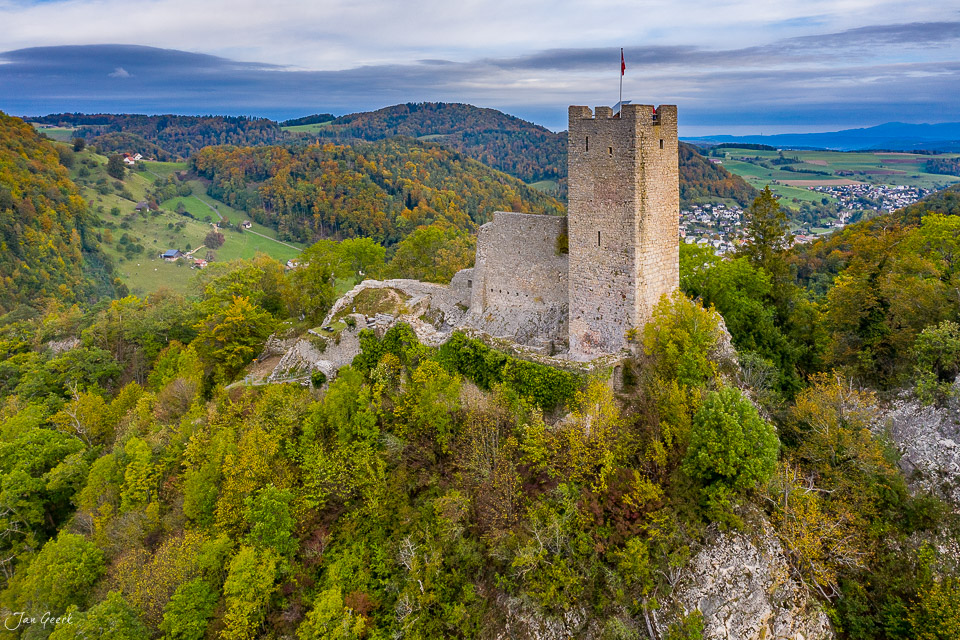 Burgruine Waldenburg auf Felsen mit Herbstwald, grüne Hügel und Dorf, Baselland Schweiz – Jan Geerk Fotograf Basel