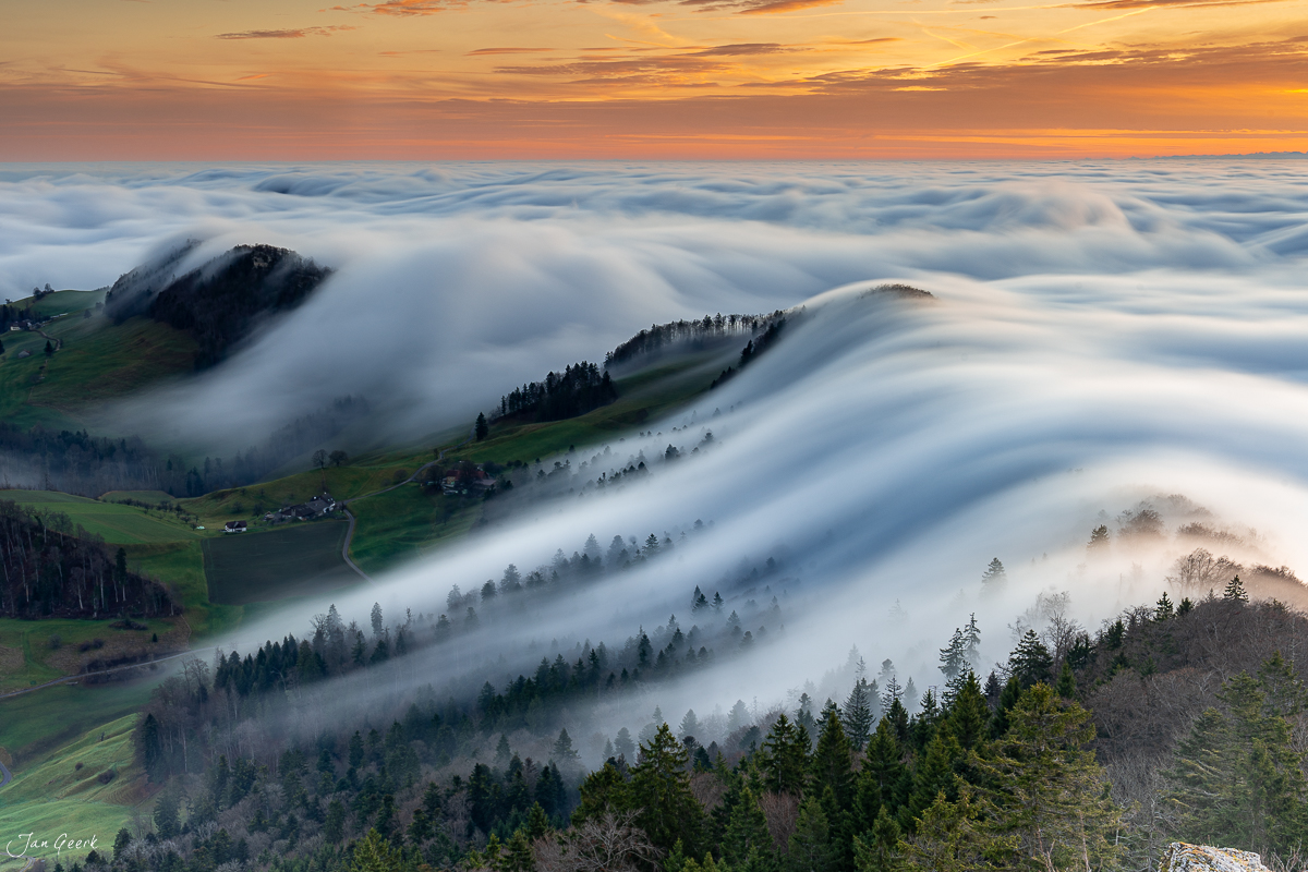Spektakuläre Nebelwelle über dem Belchen mit grünen Hängen, Waldflächen und Sonnenaufgang in der Schweiz – Jan Geerk Fotograf Basel