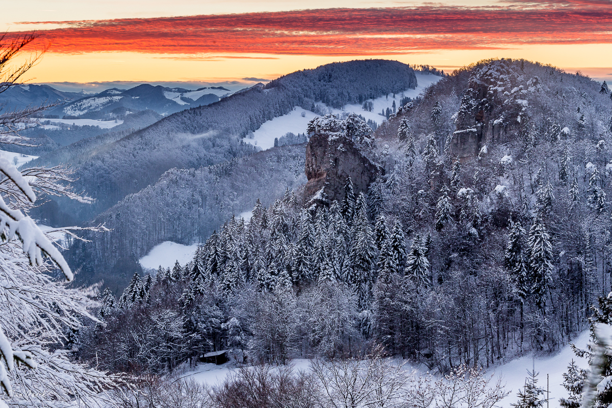 Schneebedeckte Waldhöhen mit Felsformation am Bölchen bei Sonnenaufgang im Jura, Nordwestschweiz – Jan Geerk Fotograf Basel