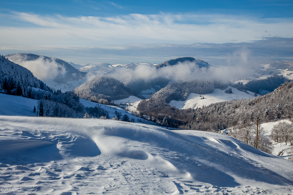 Schneebedeckte Landschaft am Bölchen mit Nebelwellen über den Jurahöhen im Winter, Baselland Schweiz – Jan Geerk Fotograf Basel