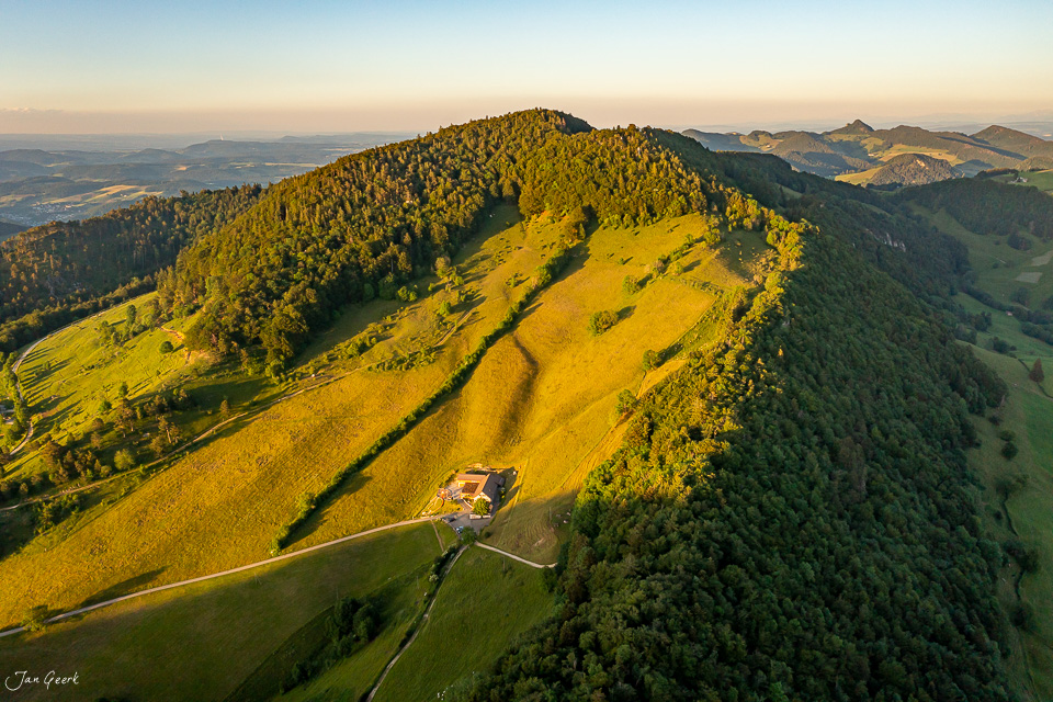Luftaufnahme des Chellechöpfli mit Berghaus, grüne Alpwiesen und Wälder im Sommer, Baselland Schweiz – Jan Geerk Fotograf Basel