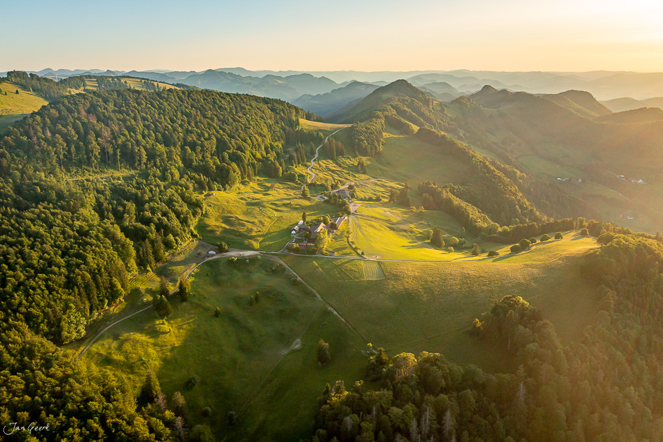 Luftaufnahme Chellechöpfli mit Wäldern und Bergpanorama im goldenen Sommerlicht, Baselland Schweiz – Jan Geerk Fotograf Basel