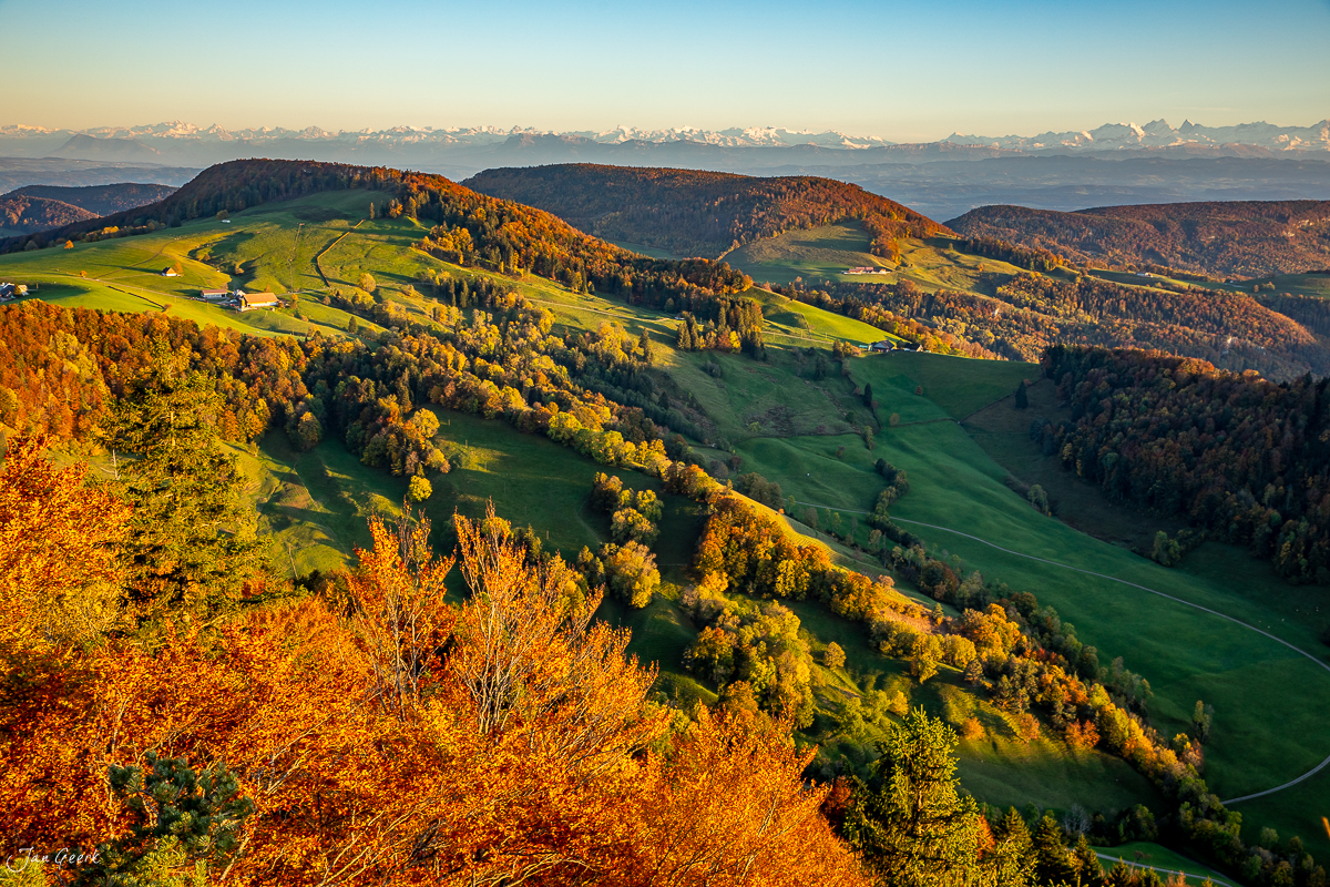 Herbstliche Berglandschaft Passwang mit goldenen Laubbäumen, grünen Wiesen und Alpenpanorama Schweiz – Jan Geerk Fotograf Basel