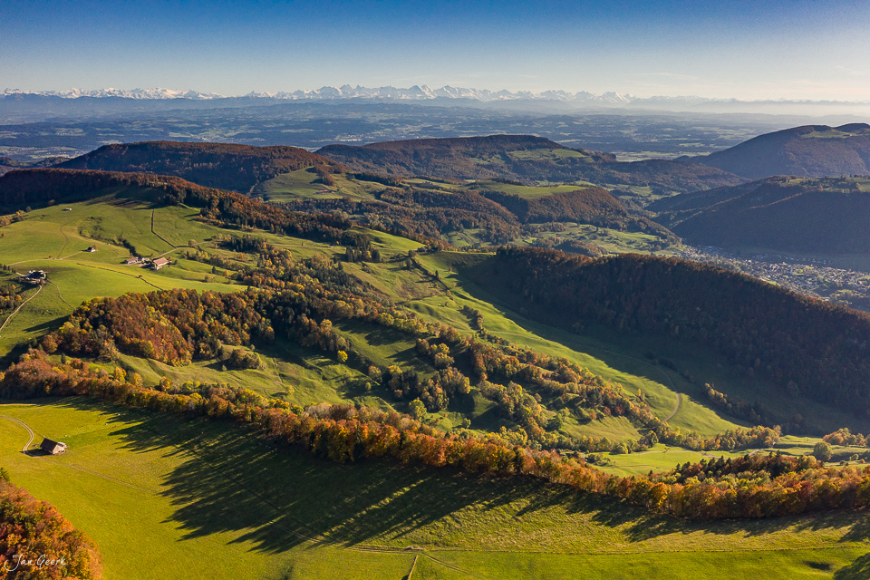 Herbstliche Berglandschaft am Chellechöpfli mit grünen Wiesen, golden gefärbten Wäldern und Alpensicht in der Schweiz – Jan Geerk Fotograf Basel