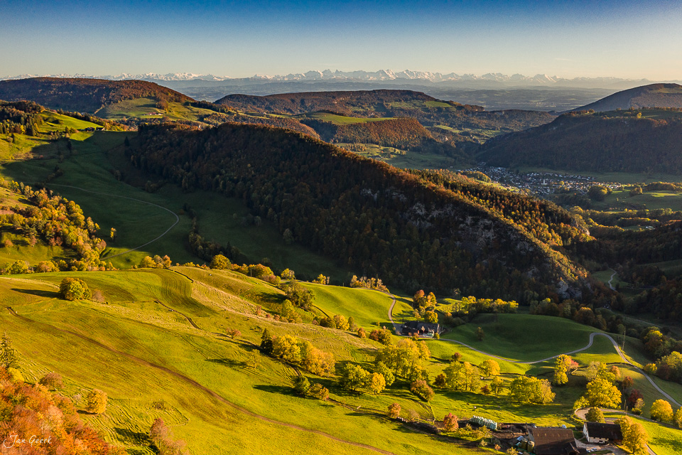 Herbstliche Hügellandschaft Passwang mit grünen Wiesen, Wäldern und Alpensicht bei Sonnenaufgang – Jan Geerk Fotograf Basel Schweiz