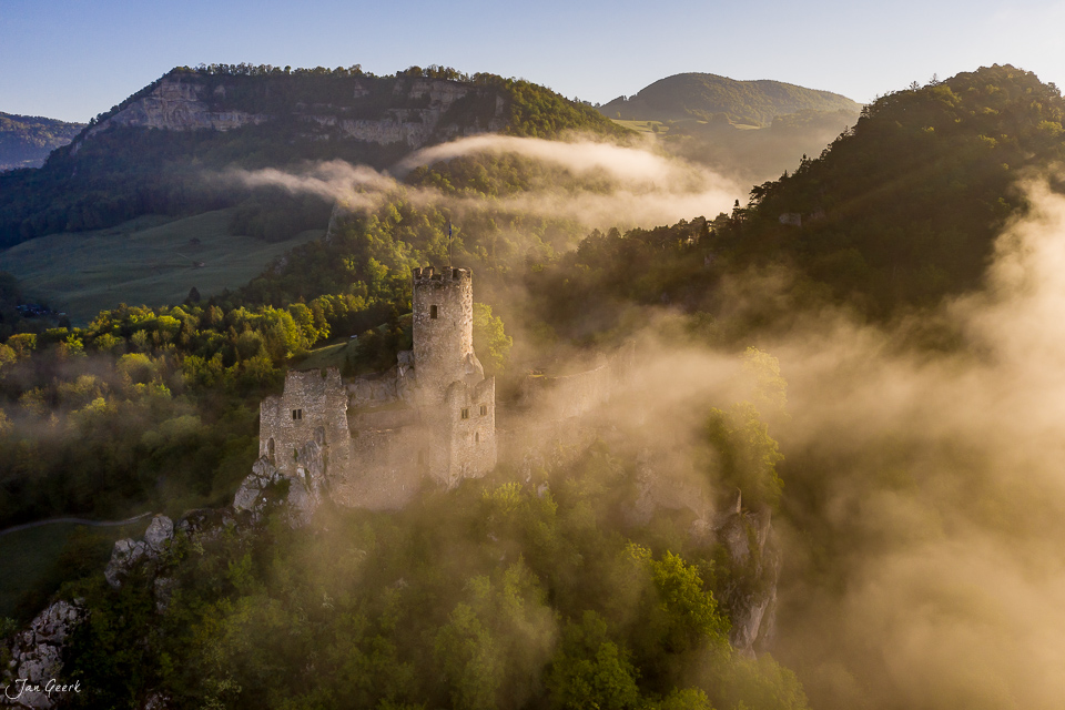 Burgruine Falkenstein im Nebel mit bewaldeten Jura-Bergen, Frühjahrsatmosphäre, Nordwestschweiz – Jan Geerk Fotograf Basel