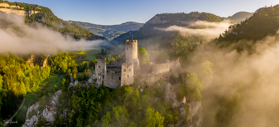 Luftaufnahme Burgfalkenstein im Nebel mit grünem Tal und Bergen Jura Schweiz Jan Geerk Fotograf Basel