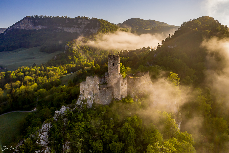 Schloss Falkenstein in Nebel und Frühjahrslichtsicht umgeben von grünen Jurawäldern Schweiz – Jan Geerk Fotograf Basel