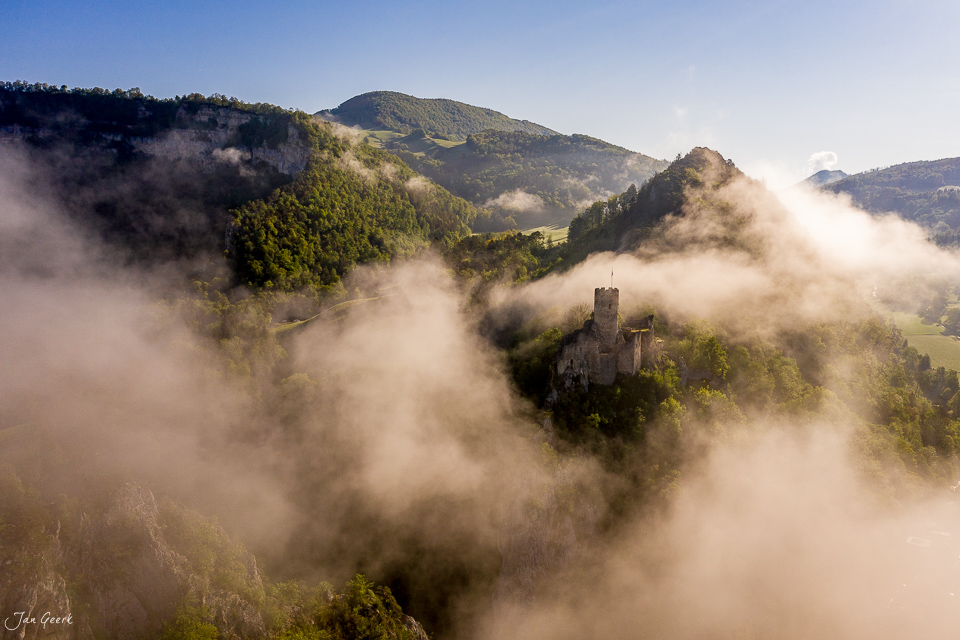 Burgruine Falkenstein im Nebel mit bewaldeten Jura-Bergen, Frühjahrsatmosphäre, Nordwestschweiz – Jan Geerk Fotograf Basel
