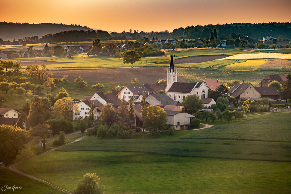 Dorfansicht Kilchberg mit Kirche, grüne Landschaft, goldenes Kantlicht, Baselland Schweiz – Jan Geerk Fotograf Basel