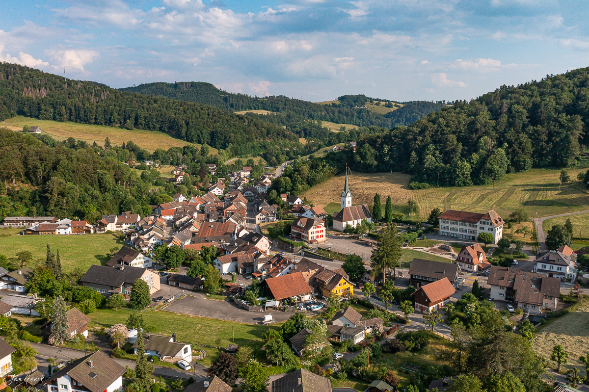 Luftaufnahme Langenbruck mit Kirche, Häusern und grünen Hügeln im Sommer, Baselland Schweiz – Jan Geerk Fotograf Basel
