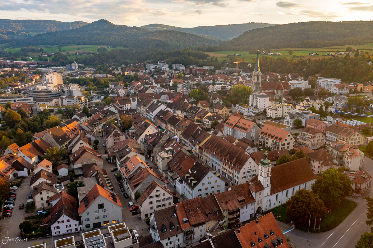 Luftaufnahme Laufen mit Kirche und Häusern, Herbstlicht, Baselland Schweiz – Jan Geerk Fotograf Basel