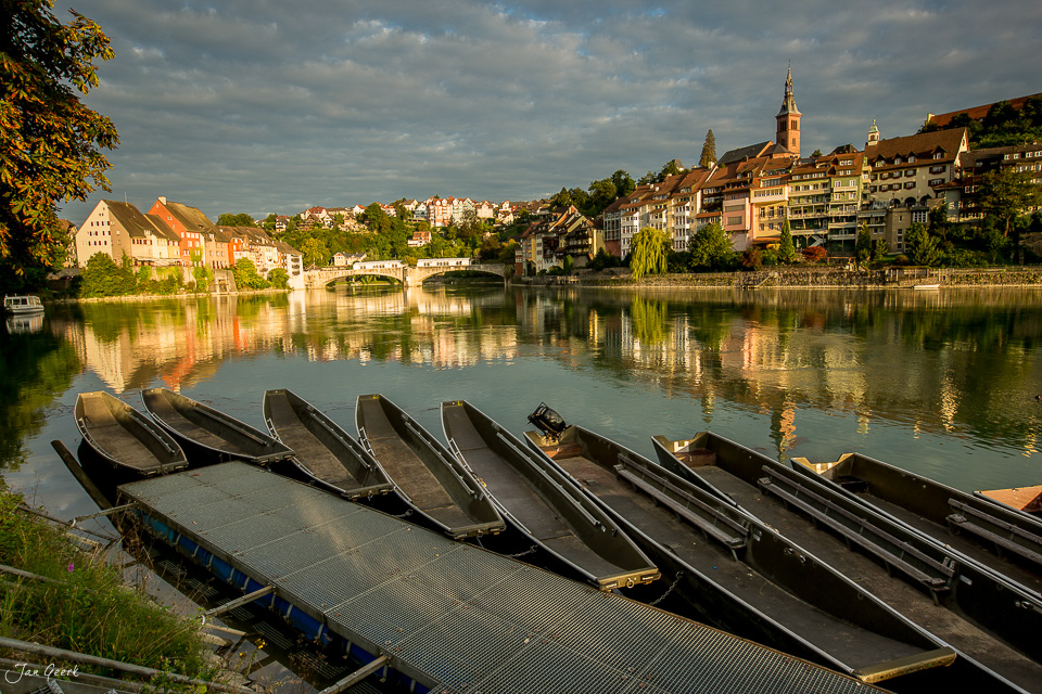 Schwarze Ruderboote am Rhein in Laufenburg bei Sommerlicht, Schweiz – Jan Geerk Fotograf Basel