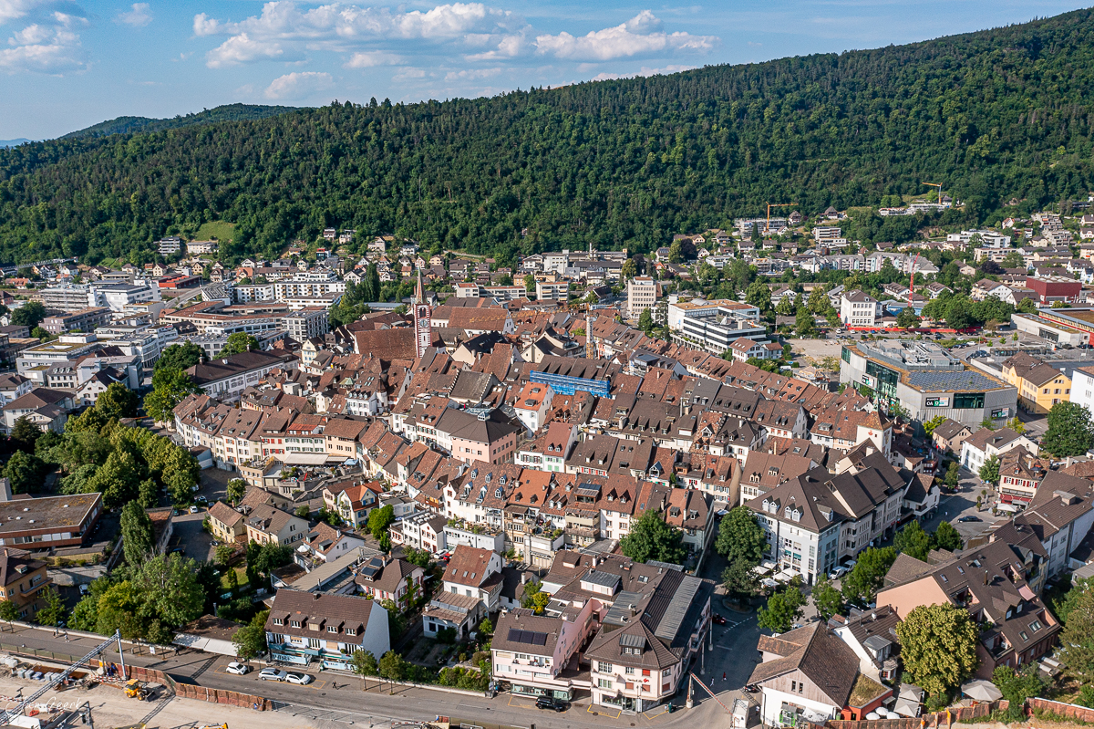 Luftaufnahme der Altstadt Liestal mit roten Dächern, umgeben von grünen Wäldern im Sommer, Baselland Schweiz – Jan Geerk Fotograf Basel