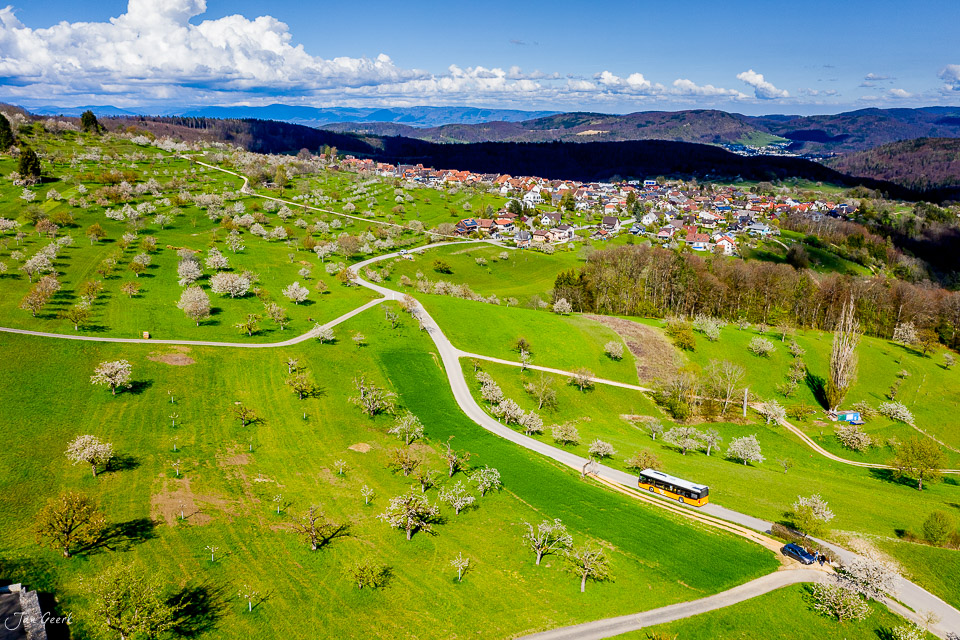 Luftaufnahme Nuglar-St. Pantaleon im Frühling mit blühenden Kirschbäumen und grünen Wiesen, Nordwestschweiz – Jan Geerk Fotograf Basel