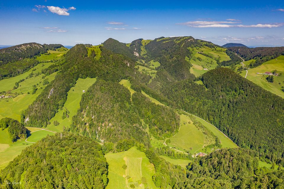 Luftaufnahme Nunningen mit grünen Hügeln, Wäldern und Feldern im Sommer, Baselland Schweiz – Jan Geerk Fotograf Basel