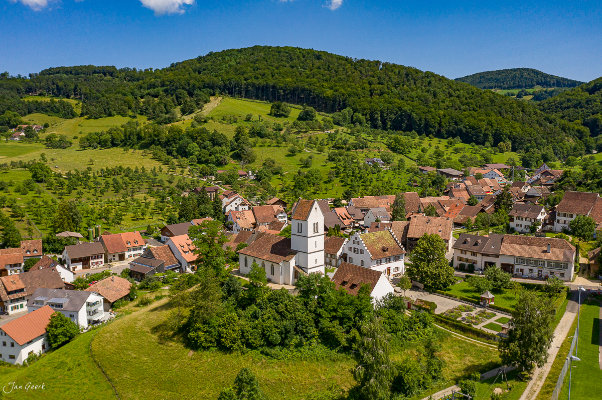 Luftaufnahme Oltingen mit Kirche, grüne Hügellandschaft, Sommer, Baselland Schweiz – Jan Geerk Fotograf Basel