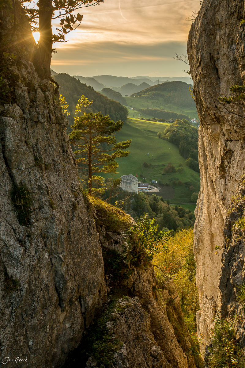 Felsschlucht mit Ausblick auf grüne Juraweiden und Herbstwald bei Portifluh Baselland Schweiz Jan Geerk Fotograf Basel