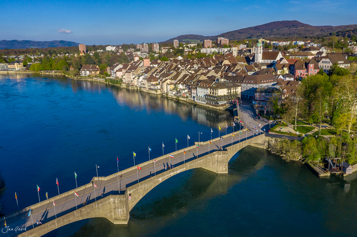 Rheinbrücke mit Flaggen und Altstadt Rheinfelden am Rhein im Frühling, Aargau Schweiz – Jan Geerk Fotograf Basel