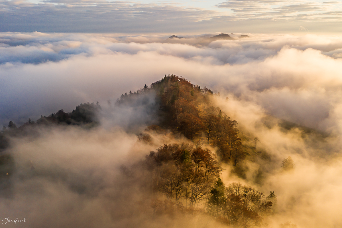 Bergkuppe mit Herbstwald über Nebelmeer am Scheltenpass, goldene Herbstlichtstimmung, Nordwestschweiz – Jan Geerk Fotograf Basel