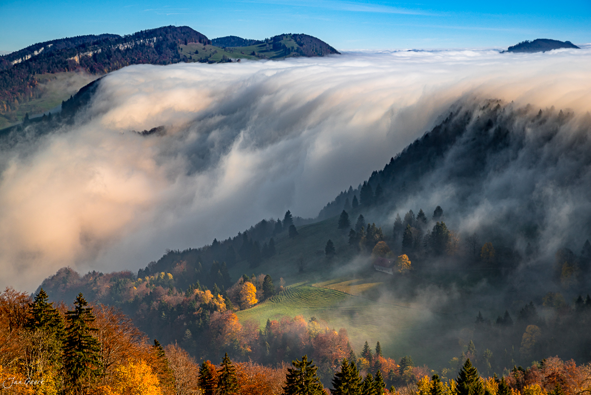 Nebelwelle über dem Scheltenpass im Herbst, Jura-Landschaft mit Wald und Wiesen, Schweiz – Jan Geerk Fotograf Basel