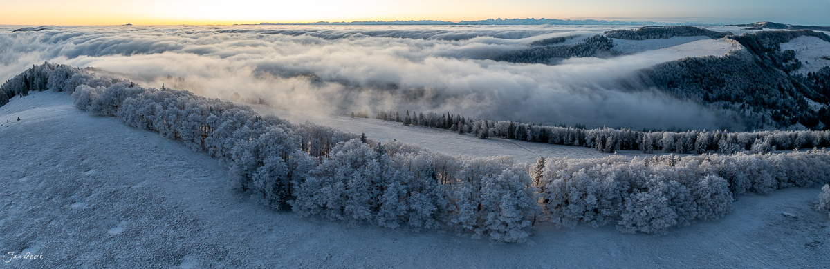Winterlandschaft am Scheltenpass mit schneebedeckten Wäldern und Nebelwellen bei Sonnenaufgang Schweiz Jan Geerk Fotograf Basel