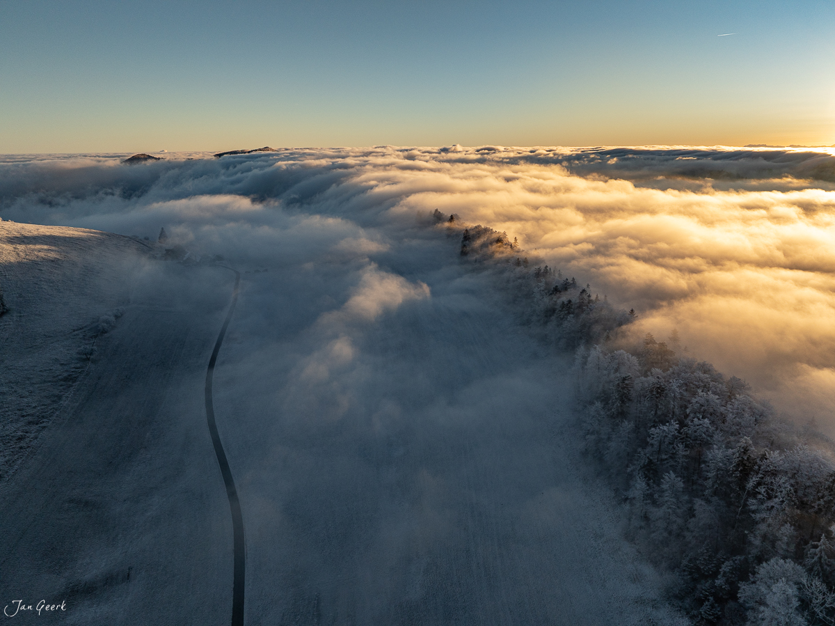 Nebelwelle über dem Scheltenpass mit verschneiten Fichten bei Sonnenaufgang, Nordwestschweiz – Jan Geerk Fotograf Basel