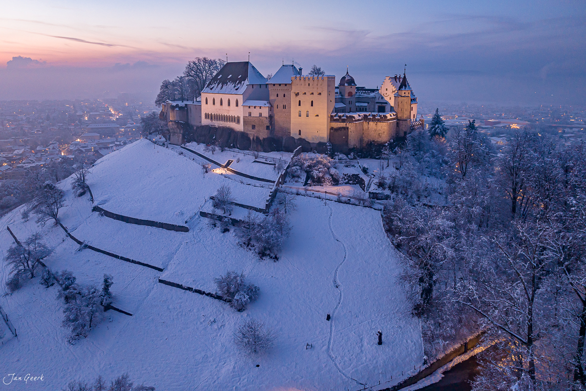 Schloss Lenzburg im Schnee bei Dämmerung, verschneite Landschaft mit beleuchteten Türmen, Aargau Schweiz – Jan Geerk Fotograf Basel