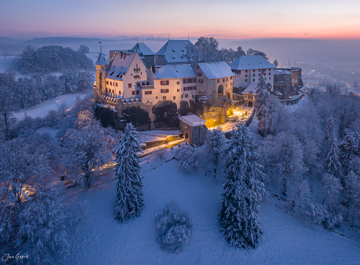 Schloss Lenzburg in Winterlandschaft mit schneebedeckten Fichten bei Sonnenaufgang, Aargau, Schweiz – Jan Geerk Fotograf Basel